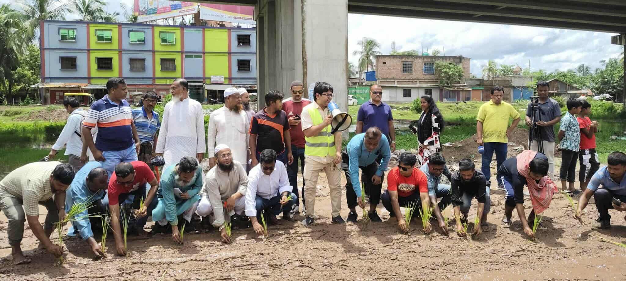 খুলনার শিপইয়ার্ড সড়কে ধানের চারা রোপণ ও লাল কার্ড দেখিয়ে নিসচা’র প্রতিবাদ